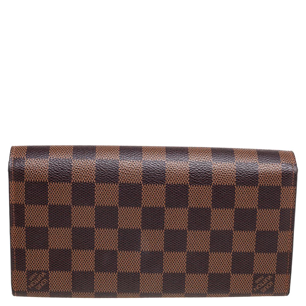 Louis Vuitton's immaculate creations like this Rosebery wallet resonate with the label's skilled craftsmanship and signature aesthetic. This wallet is styled using Damier Ebene canvas with a gold-toned logo-engraved lock closure perched on the