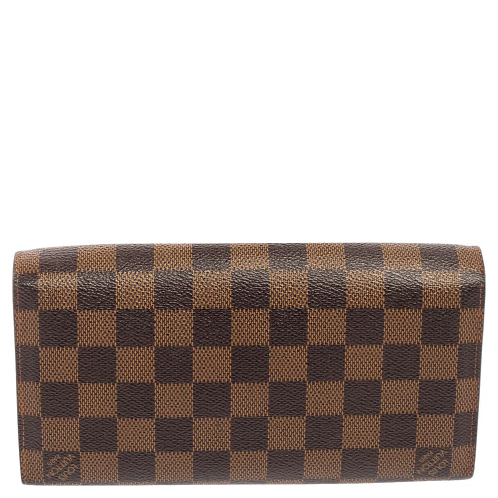 Keep your everyday belongings safe in this beautiful Rosebery wallet from the House of Louis Vuitton. It is designed using Damier Ebene canvas, with a gold-tone lock closure perched on the front. It has leather trims along with a leather-lined