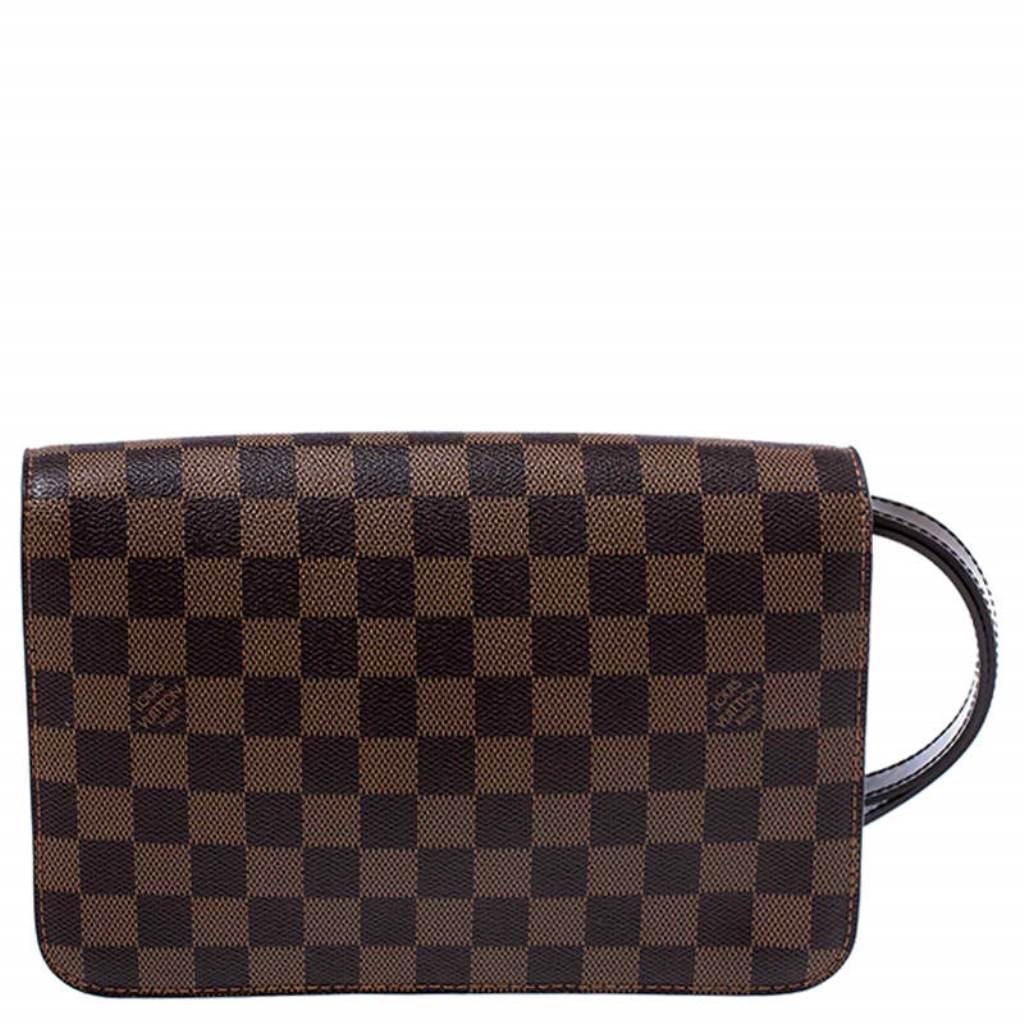 Beautifully crafted from the brand's signature Damier Ebene canvas, this Louis Vuitton clutch is a sweet buy! The piece features a gold-tone zipper which reveals an Alcantara interior perfectly sized to carry your essentials. It also features a