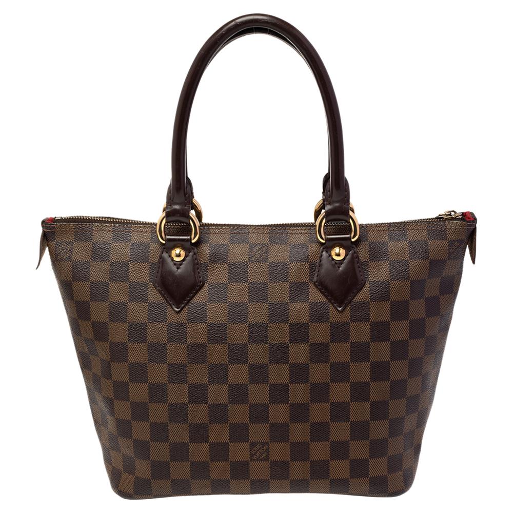 This Saleya PM by Louis Vuitton will add ease to your daily routine. Crafted from Damier Ebene canvas, it features a top zipper closure, dual handles, and polished gold-tone hardware. The Alcantara-lined interior has ample space for all your