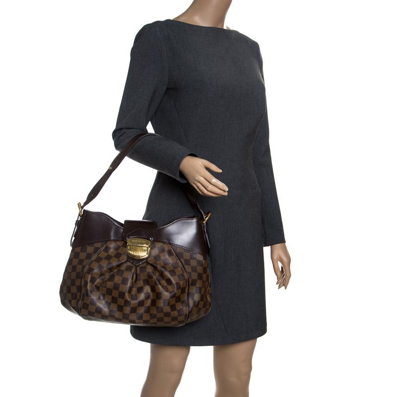 Louis Vuitton's handbags are popular owing to their high style and functionality. This Sistina MM bag, like all the other handbags, is durable and stylish. Crafted from Damier Ebene canvas and leather, the bag can be paraded using the top handle. It