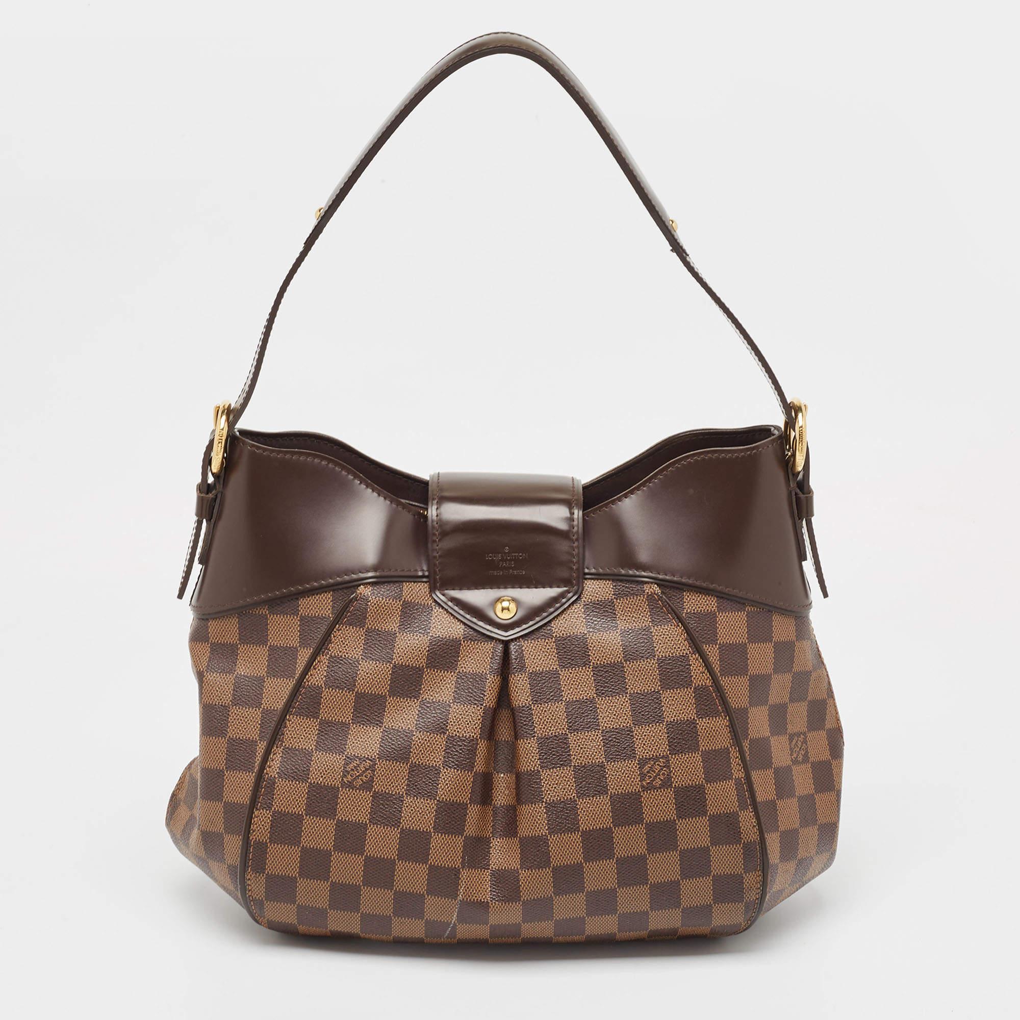 Louis Vuitton's handbags are popular thanks to their high style, durability, and functionality. This Sistina bag, like all the other designs, is lasting and stylish. Crafted from Damier Ebene canvas, the bag can be paraded using the top handles. It