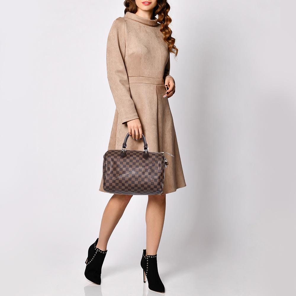 Titled as one of the greatest handbags in the history of luxury fashion, the Speedy from Louis Vuitton was first created for everyday use as a smaller version of their famous Keepall bag. This Speedy 30 comes crafted from the signature Damier Ebene