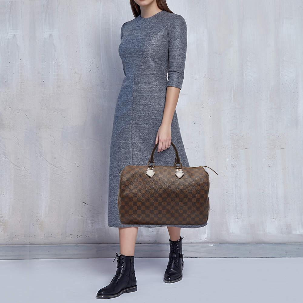 The iconic Speedy from Louis Vuitton was first created for everyday use as a smaller version of their famous Keepall bag. It is one of the most popular bags in the world today. This Speedy 35 here comes crafted from Damier Ebene canvas and added