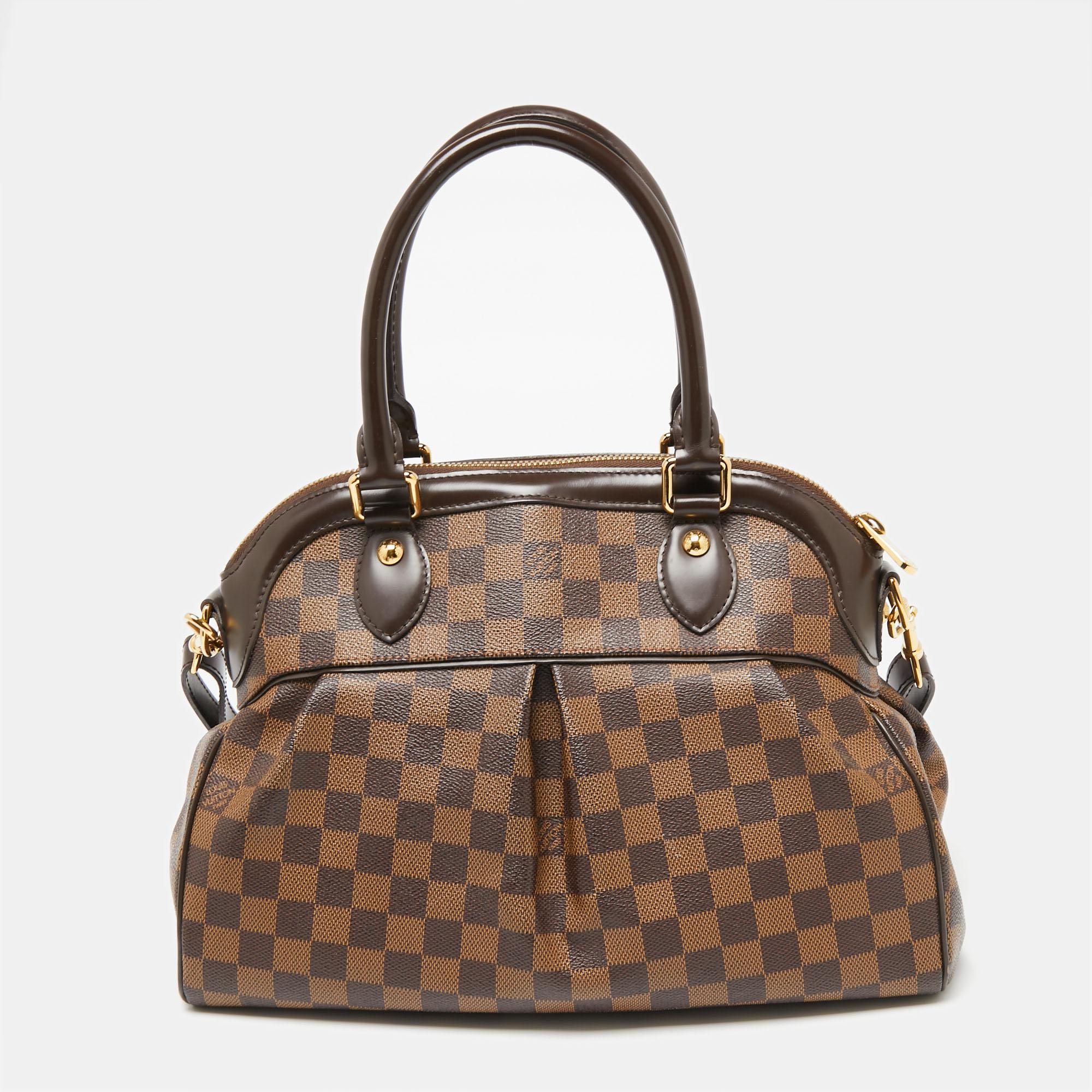 This Louis Vuitton PM bag will be one of your favorite everyday accessories. Expertly made from Damier Ebene canvas and leather trims, it features dual handles, zipper closure at the top, and a shoulder strap. The spaciously sized Alcantara-lined
