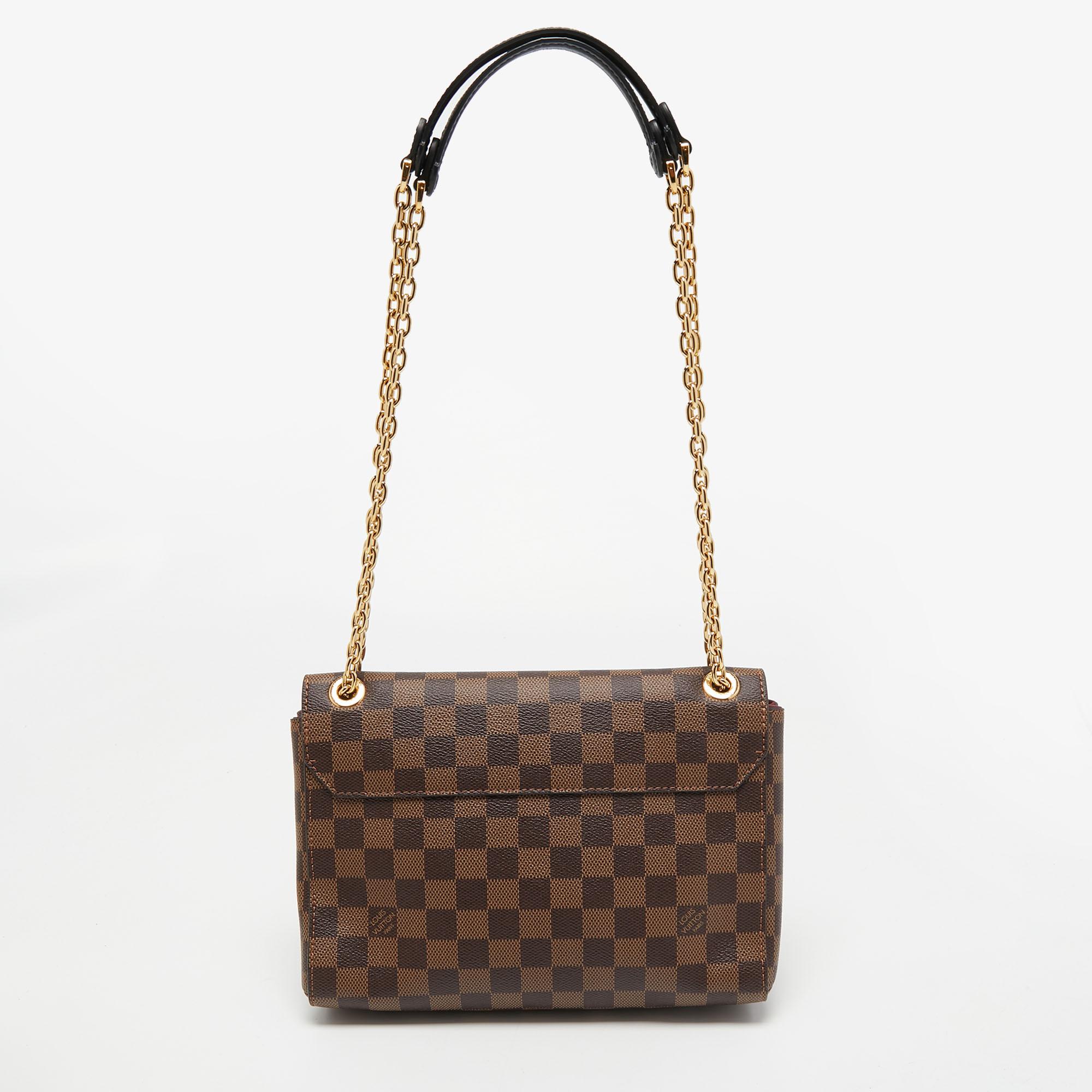 This Louis Vuitton Vavin PM bag has been beautifully crafted using Damier Ebene canvas and Bordeaux leather. The flap is adorned with a branded gold-tone lock, and the top is attached with a sliding chain handle.

Includes: Original Dustbag