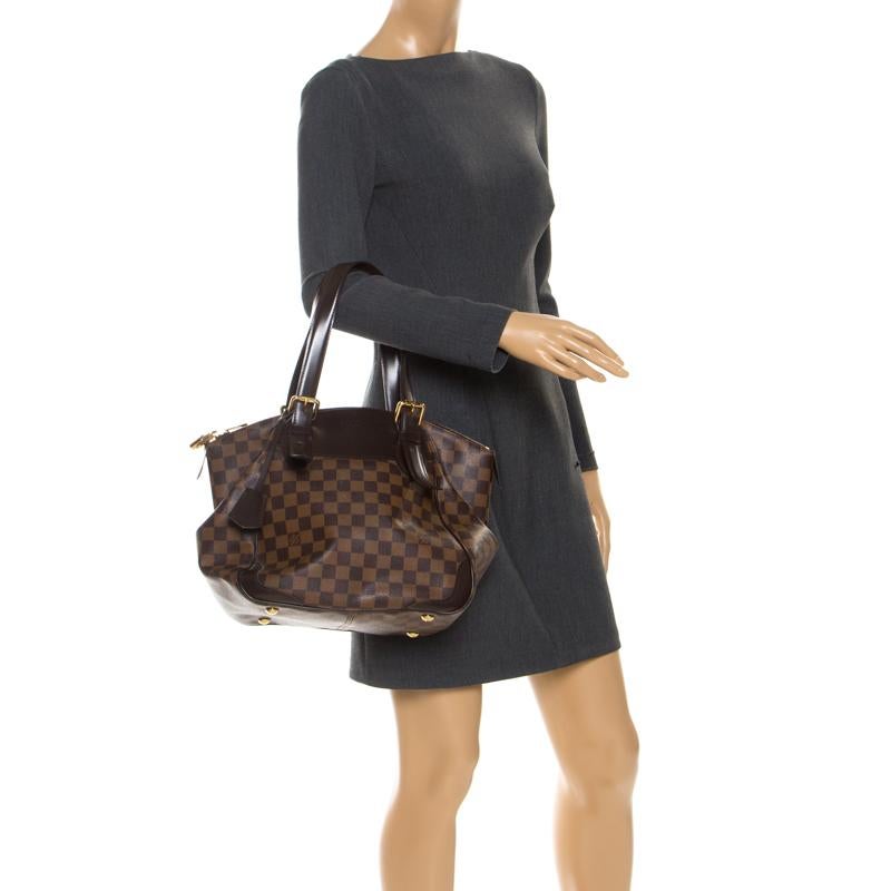This Verona MM bag, like all the other handbags from Louis Vuitton, is durable and stylish. Crafted from Damier Ebene canvas, the bag comes with two handles, a padlock and a top zipper that opens to reveal a spacious canvas interior with enough