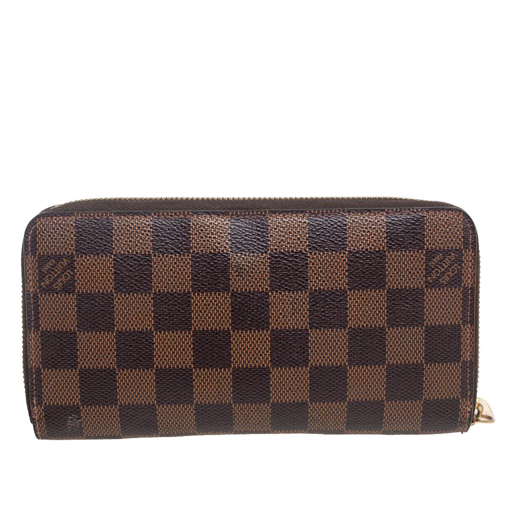 This Louis Vuitton Zippy wallet is conveniently designed for everyday use. Crafted from Damier Ebene canvas, the wallet has a wide zip closure that opens to reveal multiple slots, canvas and leather-lined compartments, and a zip pocket for you to