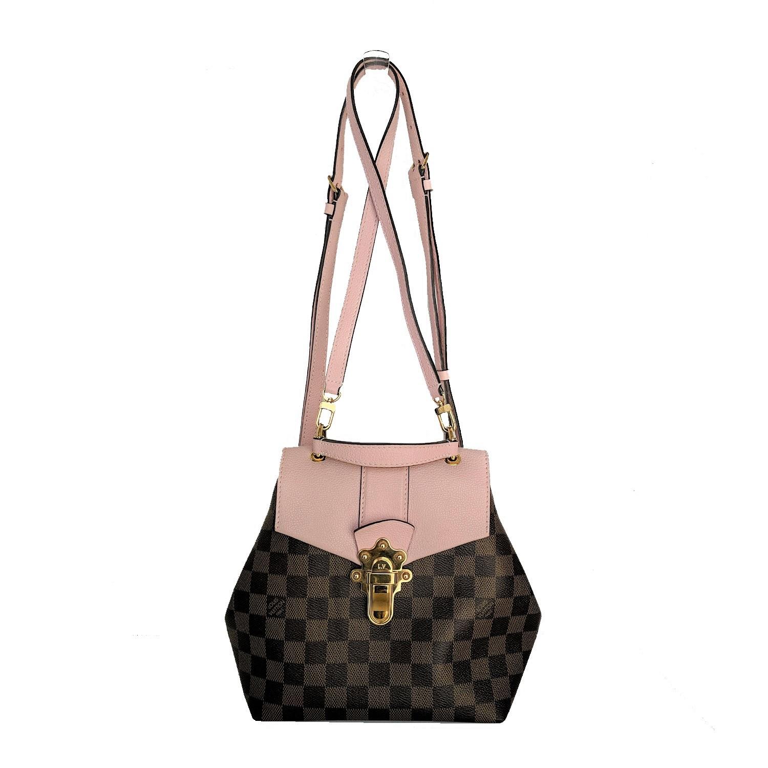 This shoulder bag features a pink grained calfskin leather front flap, a handle, optional adjustable pink leather shoulder straps and a polished brass LV press lock. The front flap opens to a light pink fabric interior with a patch pocket. This is a