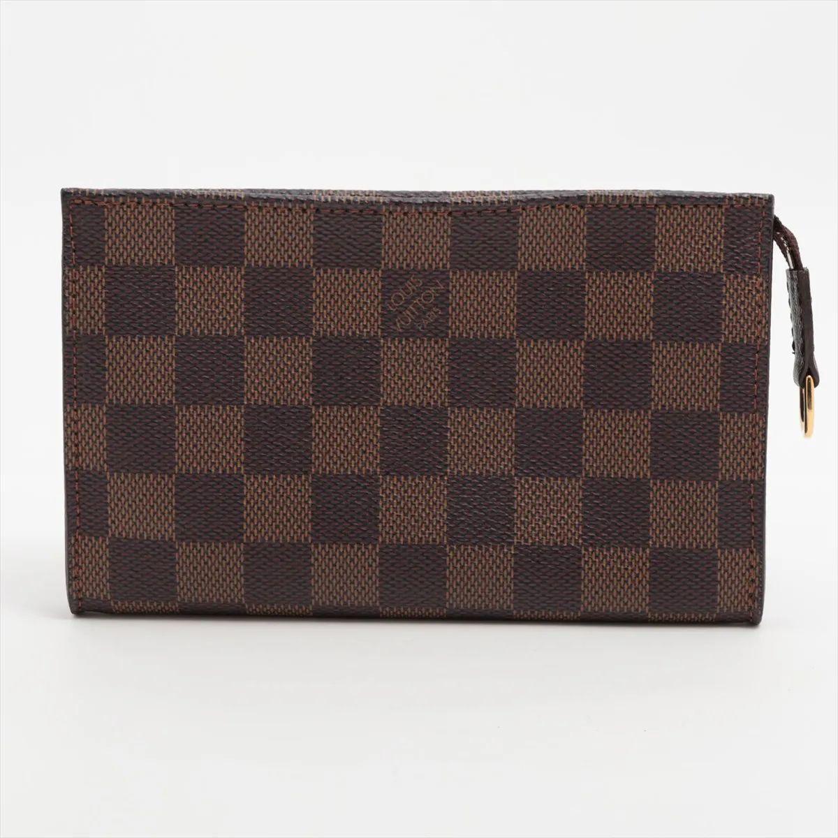 La Pochette Damier Ebene di Louis Vuitton è un accessorio sofisticato che mette in risalto l'iconica tela rivestita a quadri del marchio. Eleganza senza tempo grazie ai dettagli in pelle marrone liscia e alle finiture in oro lucido. Il design