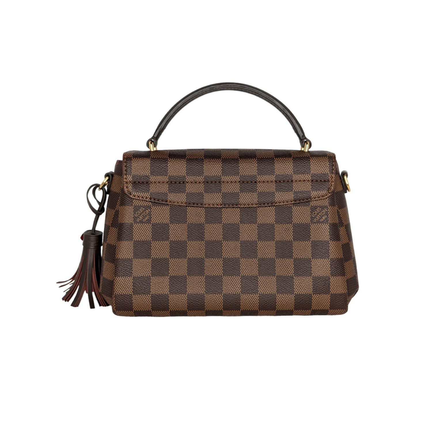 A compact bag with modern lines, the Croisette in Damier Ebene canvas boasts sophisticated details (note the signature S-lock) and a casual-chic allure. The removable leather tassel adds a touch of fun. Sized to fit the essentials plus a long