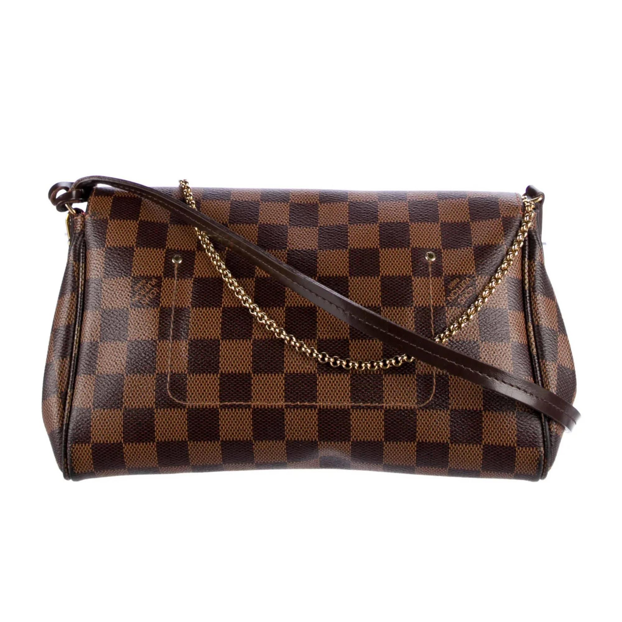 This bag is made of classic Damier toile canvas. The shoulder bag features a polished brass chain-link wristlet strap and an optional brown leather crossbody strap. The crossover flap opens with a magnetic brass bar to a fabric interior with a patch