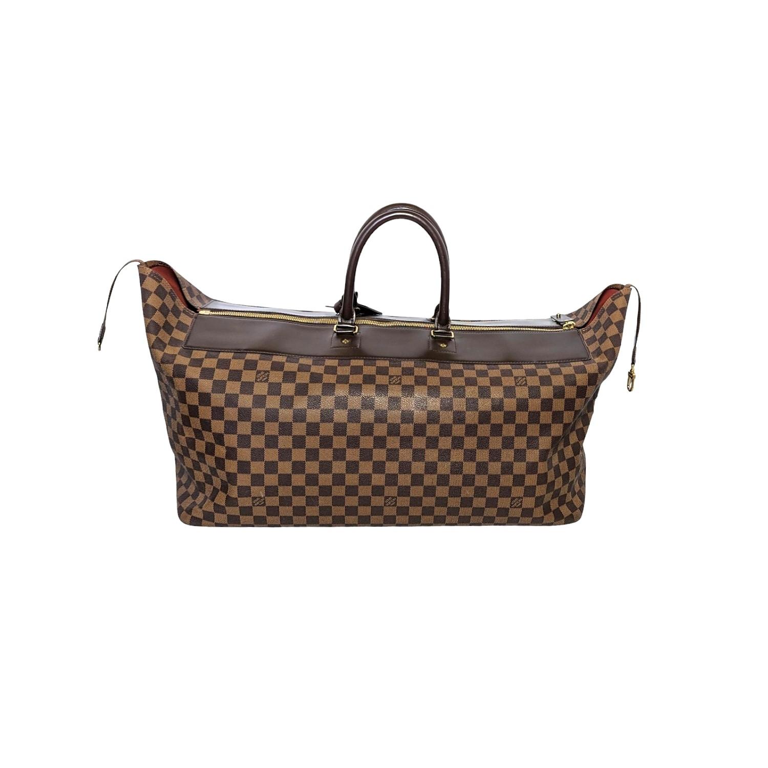 This stylish travel tote is crafted of Louis Vuitton signature Damier coated canvas in brown. The bag features rolled leather top handles, and brass hardware. The top zipper opens to a spacious orange fabric interior with a hanging zipper pocket.