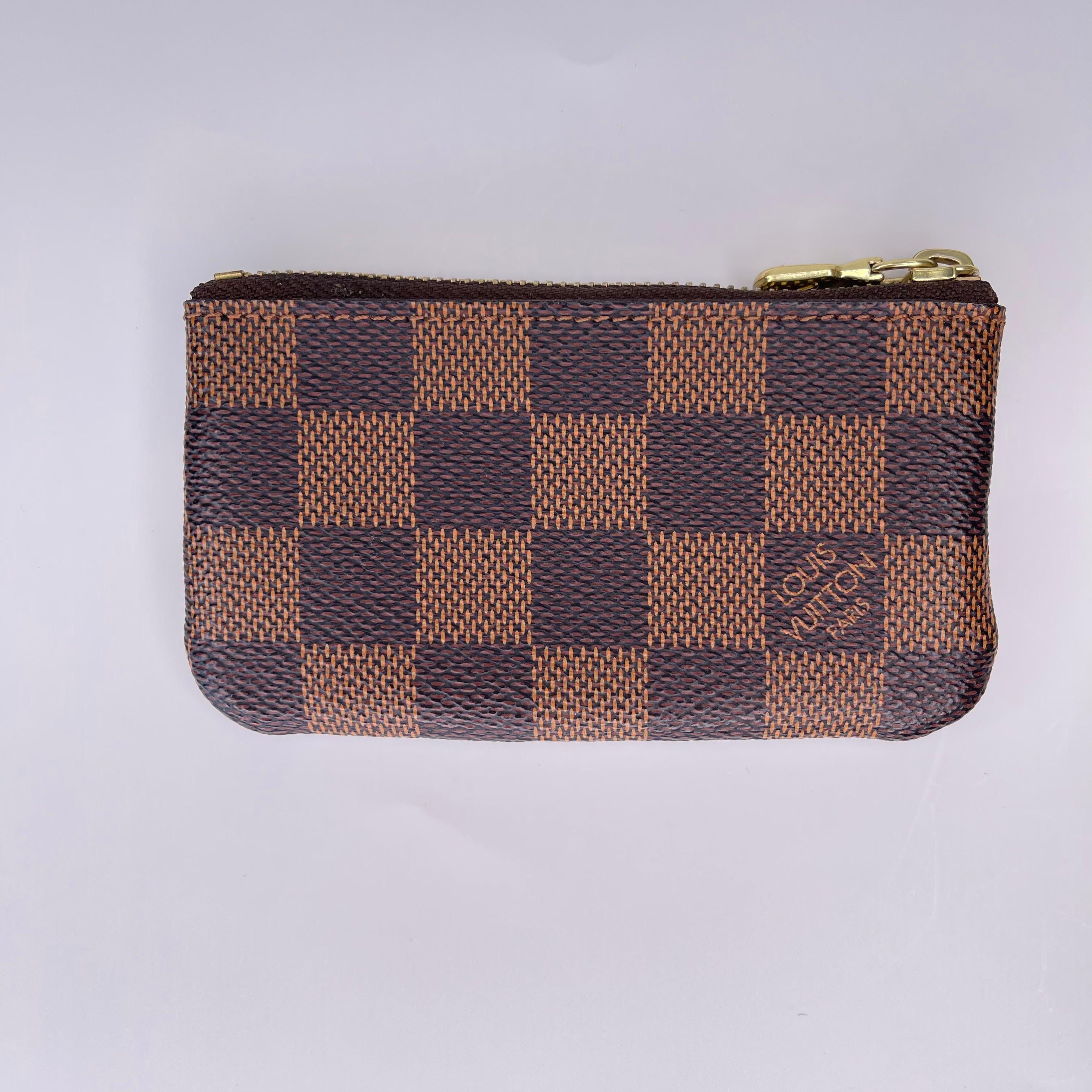 COLOR: Brown/Damier Ebene
MATERIAL: Coated canvas
MEASURES: H 2” x L 3.5”
COMES WITH: Dust bag, box & Receipt
CONDITION: Good - minimal signs of use.

Made in Spain