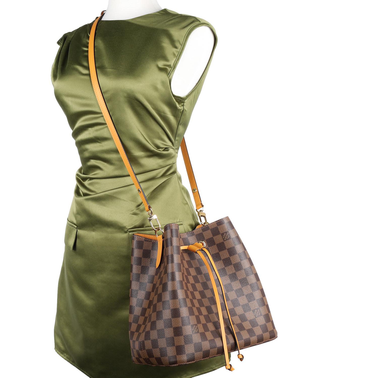 Authentic Damier Ebene Neonoe MM Bucket Bag in Safran. This bucket bag is both boldly fashionable and remarkably practical, thanks to its body-friendly and lightweight construction. Its adjustable strap enables two carrying styles: shoulder or