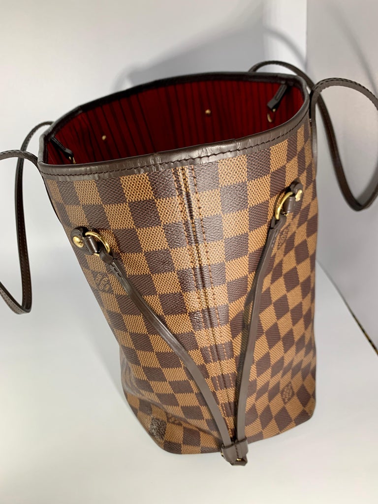 Louis Vuitton Damier Ebene Neverfull MM Shoulder Bag Canvas Purse in excellent condition
Gently used Louis Vuitton Neverfull MM in Damier Ebene

 Featuring a tonal leather trim and Red Interior
Bag is in Very good  condition . 
Handels show some