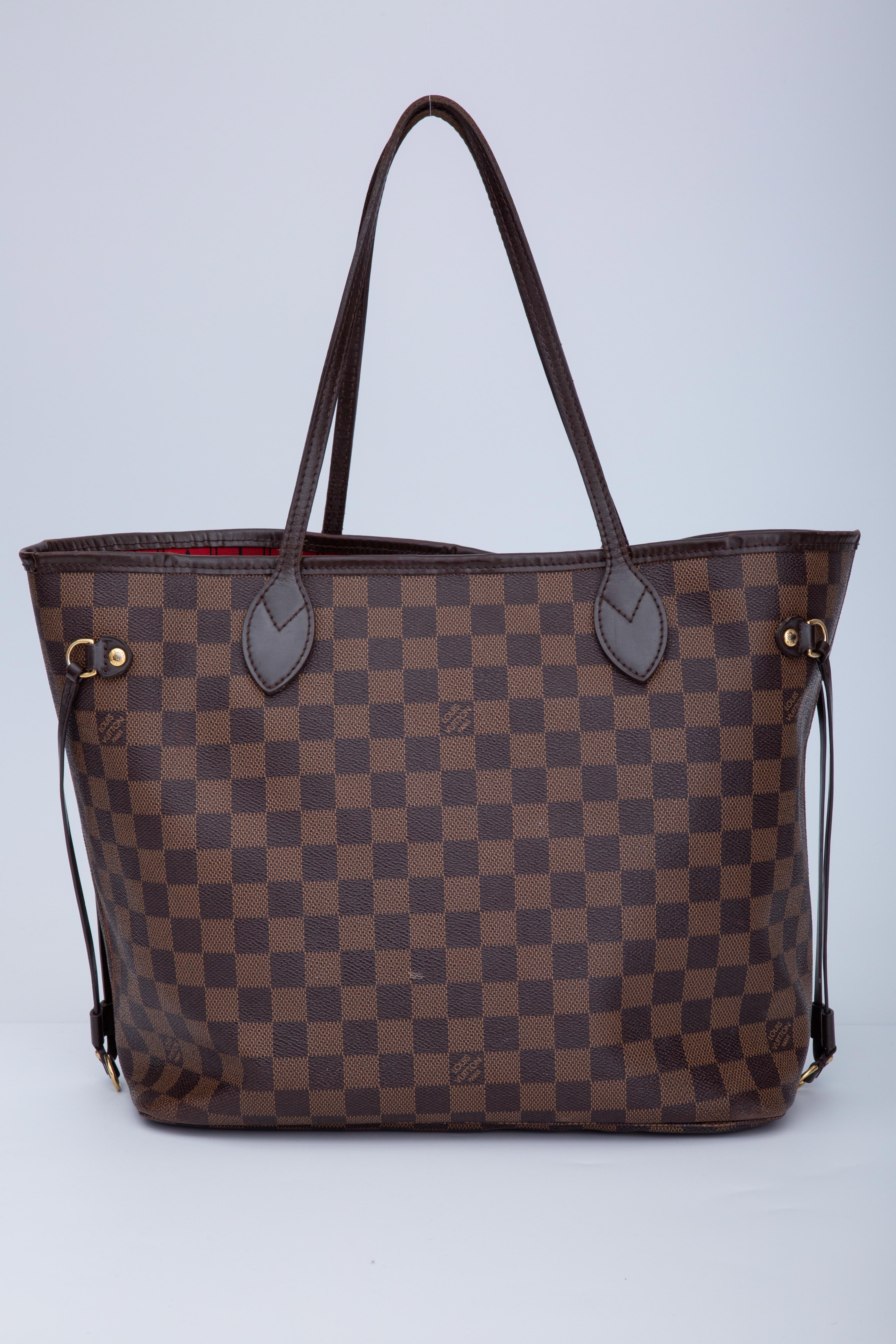 The medium version from Louis Vuitton's classic Neverfull tote collection is made with damier ebene coated canvas with smooth brown leather trim and finishes. The leather on this bag is water and stain resistant. The bag is finished with gold-tone