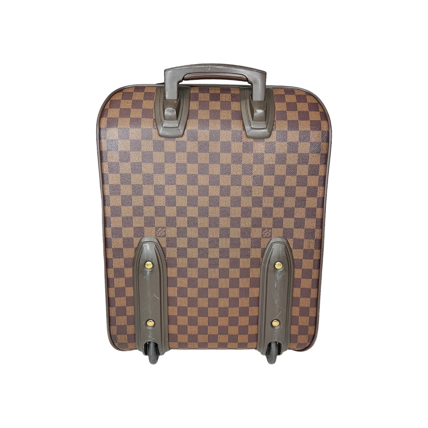 This Louis Vuitton Damier Ebene Pegase 45 was made in France in 2002 and it is finely crafted of the classic Louis Vuitton Damier Ebene coated canvas exterior with leather trimming and gold-tone hardware features. It has a flat leather top handle