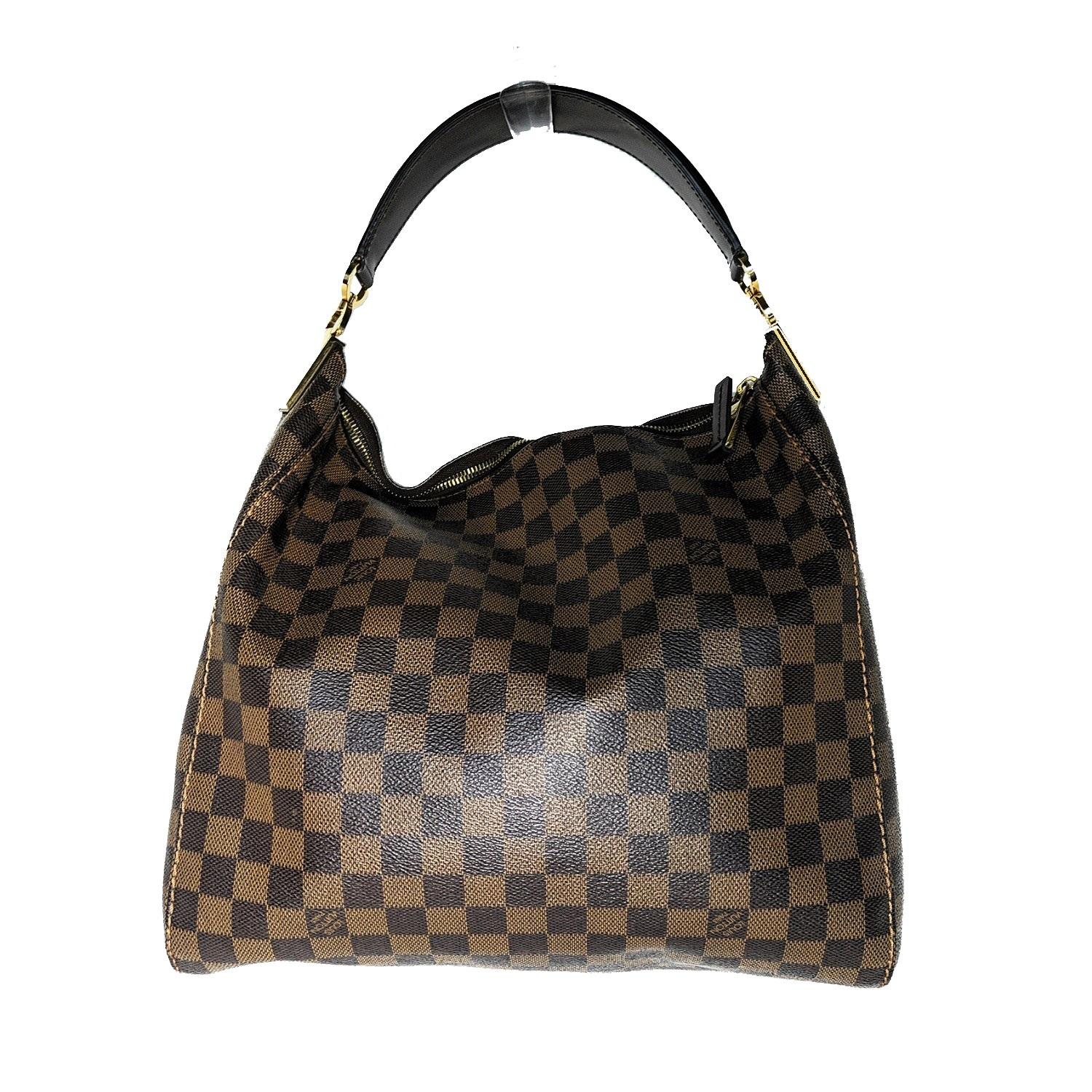 This stylish shoulder bag is finely crafted of Louis Vuitton signature Damier canvas. This bag features a side-to-side looping dark brown leather shoulder strap with polished brass hardware links and a top zipper. The zipper opens to a spacious