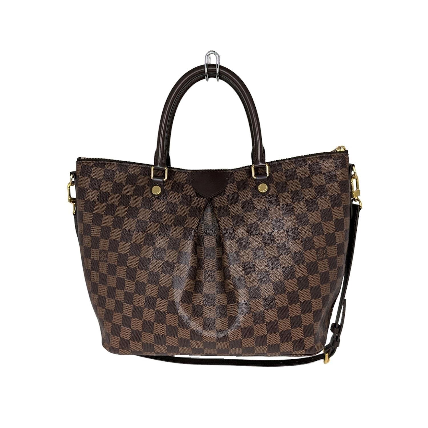 This stylish tote is crafted of Louis Vuitton Damier check canvas in ebene brown. The bag has a prominent pleat at the mid-center with rolled leather top handles and an ebene leather cross-body shoulder strap; all detailed with polished gold
