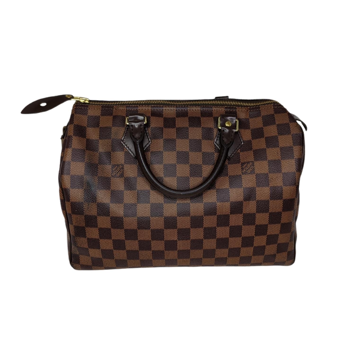 Crafted from graphic Damier Ebene canvas, the Speedy 30 is an elegant, compact handbag, a stylish companion for city life. Launched in 1930 as the 