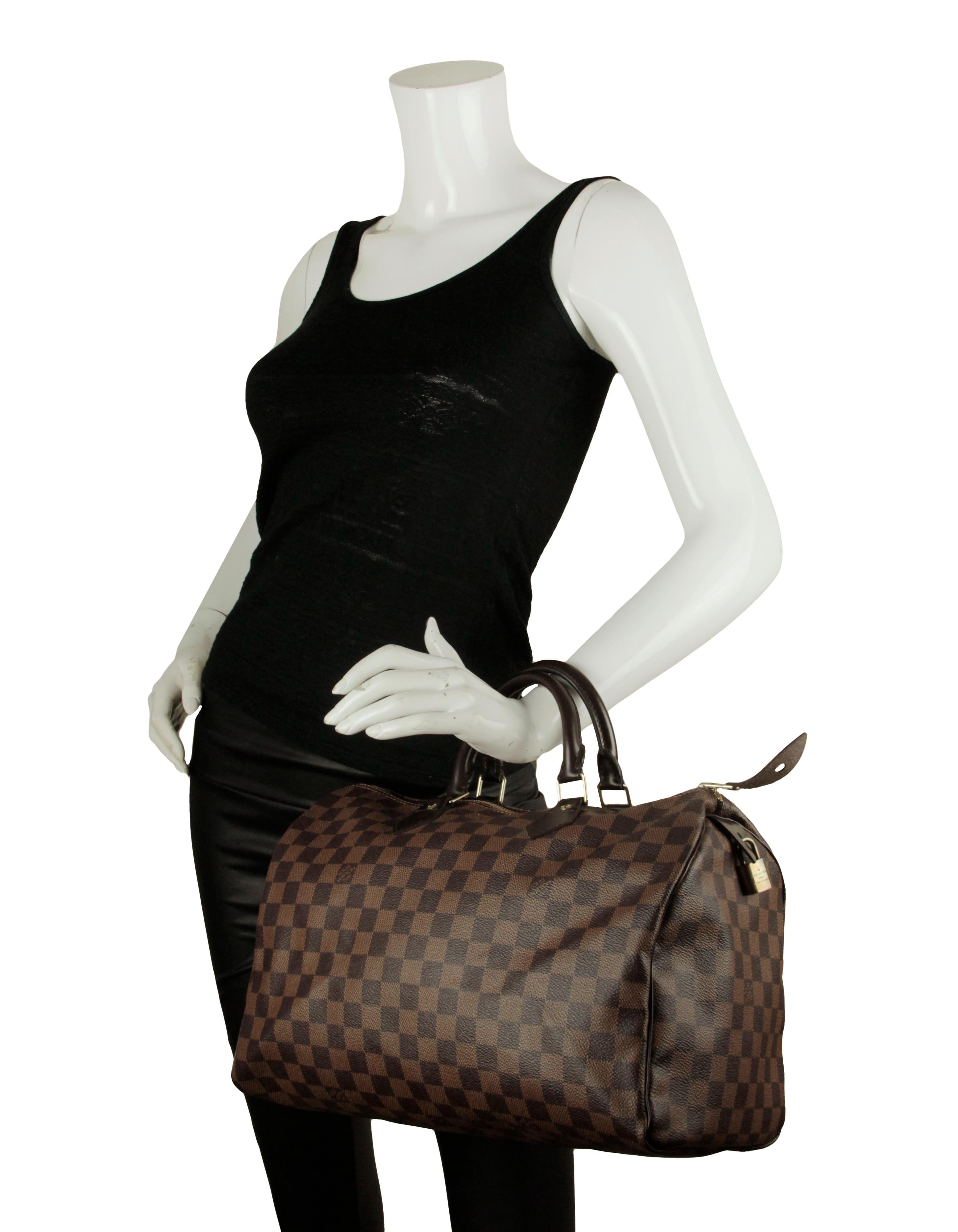 Louis Vuitton Coated Canvas Damier Ebene Speedy 35 Bag

Made In: France
Year of Production: 2008
Color: Brown
Hardware: Goldtone hardware
Materials: Coated canvas, brown leather trim
Lining: Red textile lining
Closure/Opening: Top zip
Exterior