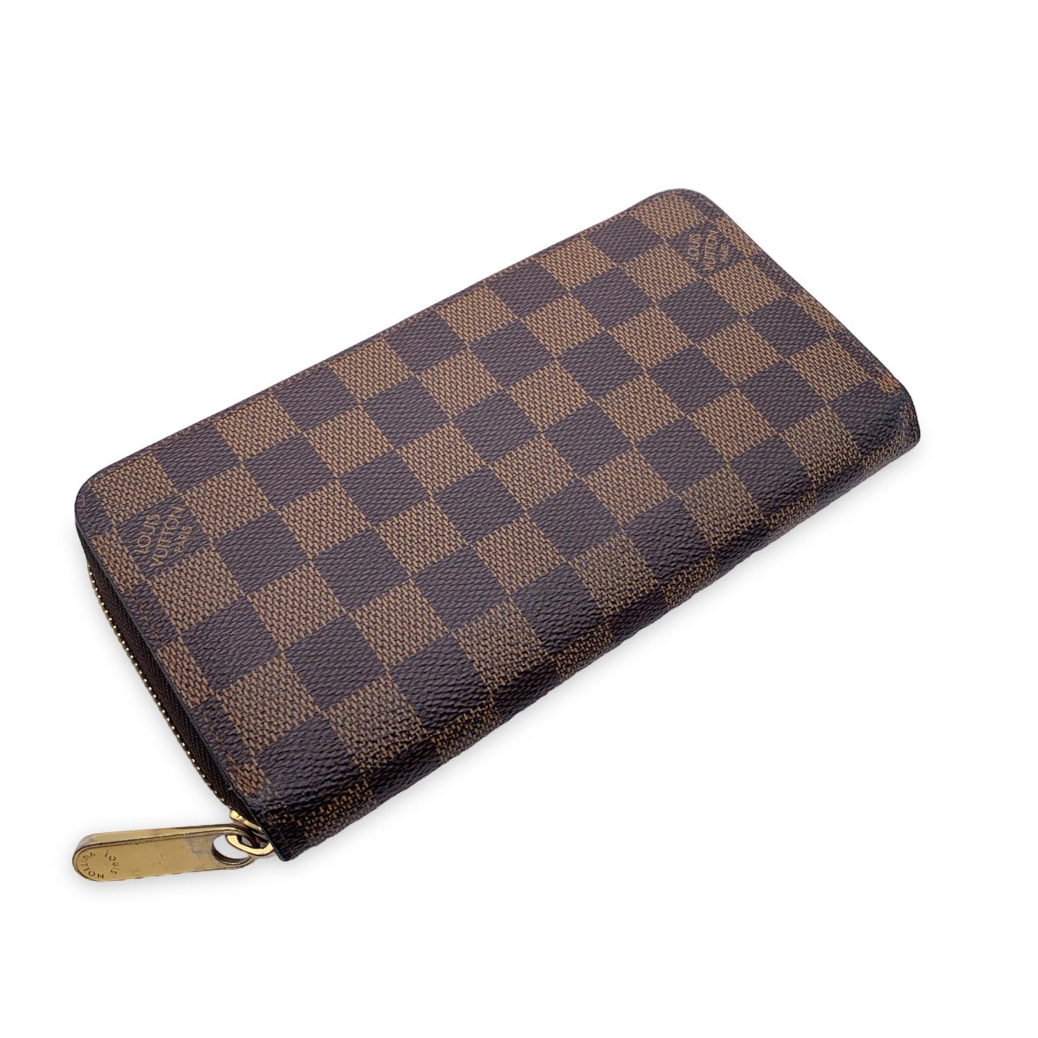 LOUIS VUITTON Damier Ebene Zippy Wallet. Zip closure. It features 2 open pockets, 1 zip coin compartment, 3 flat open pocket. 12 credit card slots. 'LOUIS VUITTON Paris - made in Spain' embossed inside. Authenticity serial number GI4136 embossed