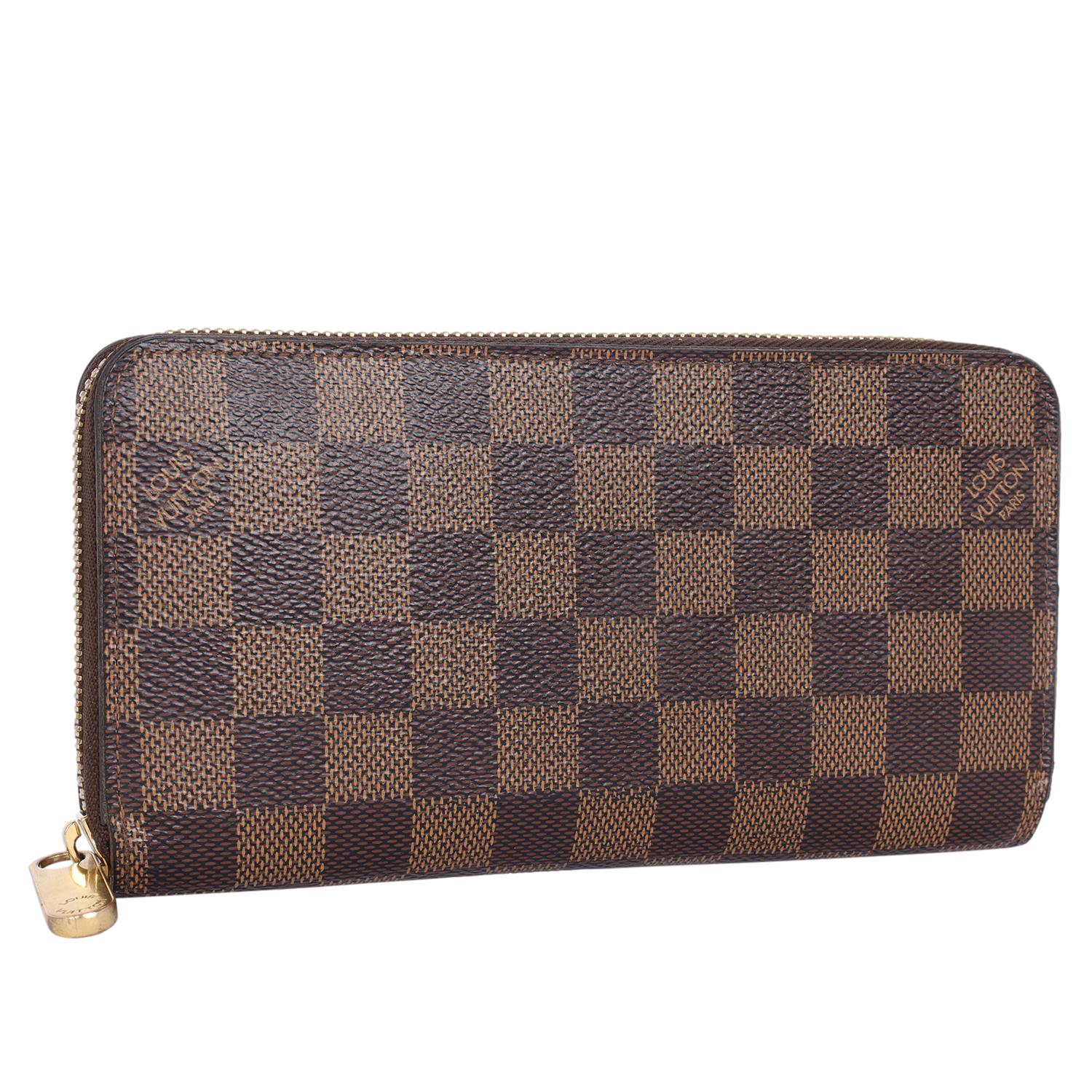 Authentic pre owned Louis Vuitton Damier Ebene Zippy Wallet with Rose Ballerine interior. The wallet features traditional damier ebene toile canvas. The wallet opens with a polished brass wrap-around zipper to a partitioned light pink cross-grain