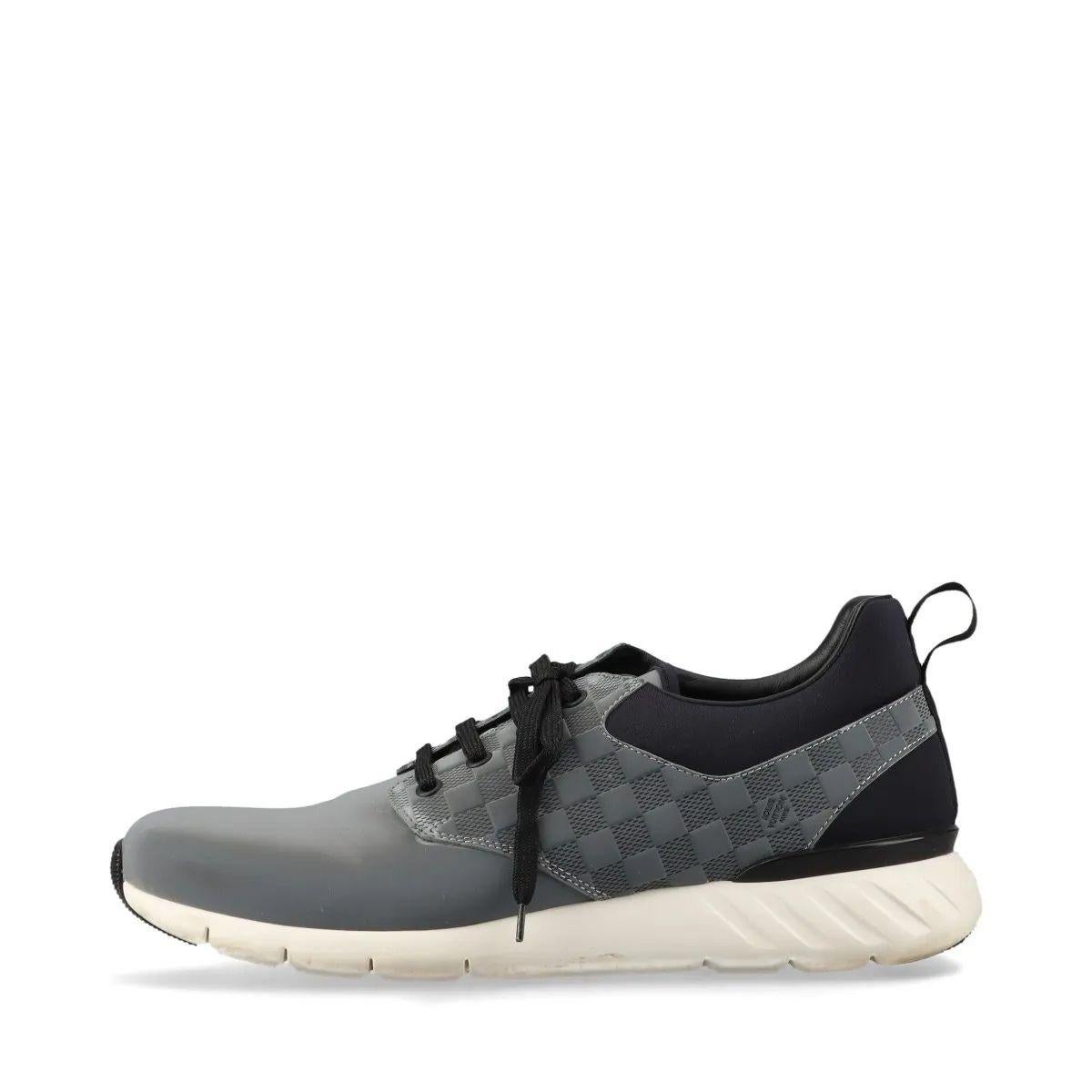 The Louis Vuitton Damier Fastlane Leather Sneaker in Gray and Black combines sporty functionality with refined elegance. Crafted from premium leather, the sneaker features the iconic Damier pattern subtly embossed across the upper in a sleek gray
