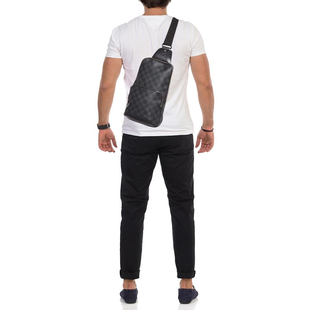 This Louis Vuitton bag will come in handy for daily use or as a style statement. It is crafted from Damier Graphite canvas and designed with a spacious interior secured by a zipper. A single crossbody strap and a front pocket make it ready to be