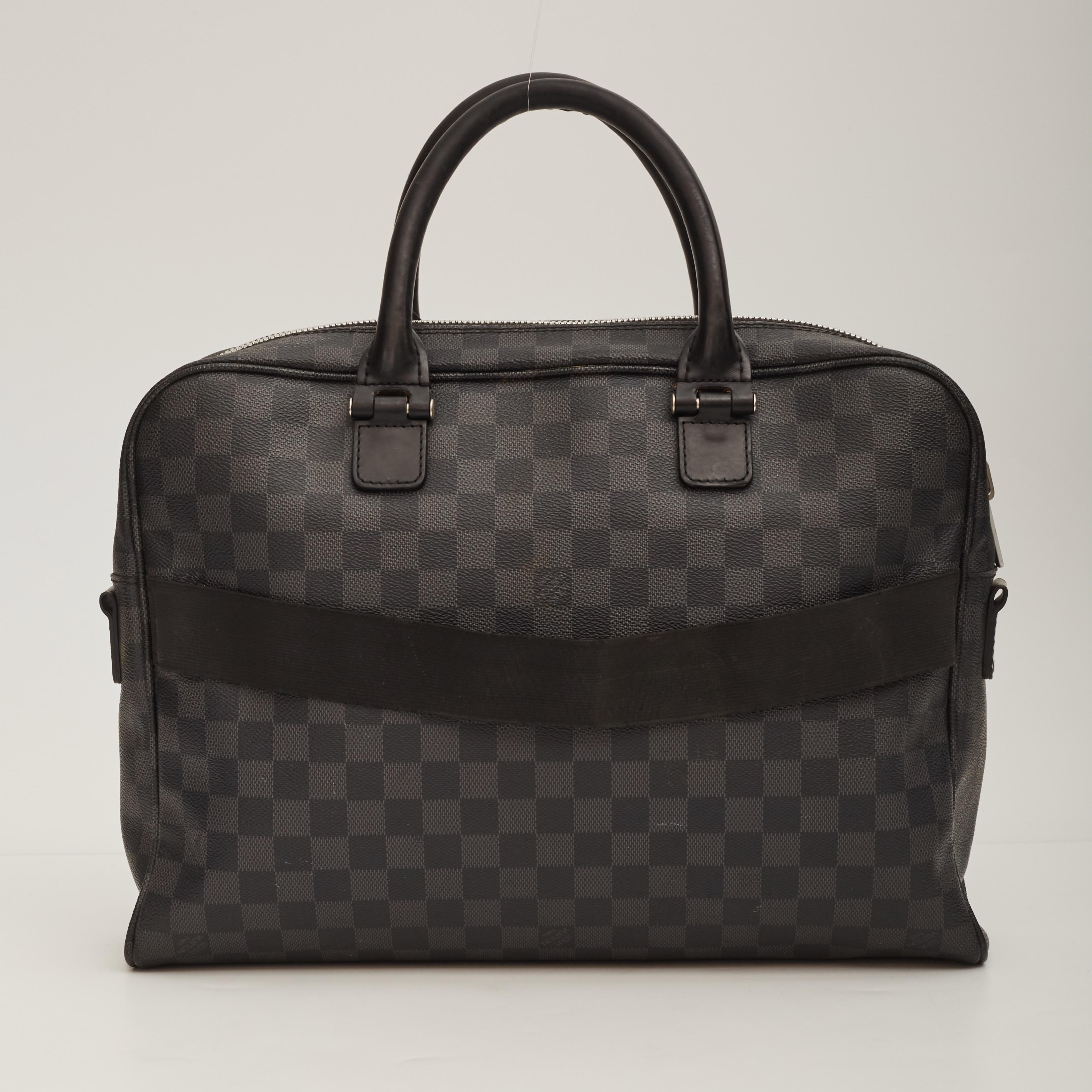 Black damier graphite coated canvas exterior. Dual rolled leather top handles. Top zip closure. Black woven fabric lining. Silver hardware. Front zip pocket. Back canvas strap. 

Color: Black
Material: Coated canvas
Date Code: SR4186
Measures: H 11”