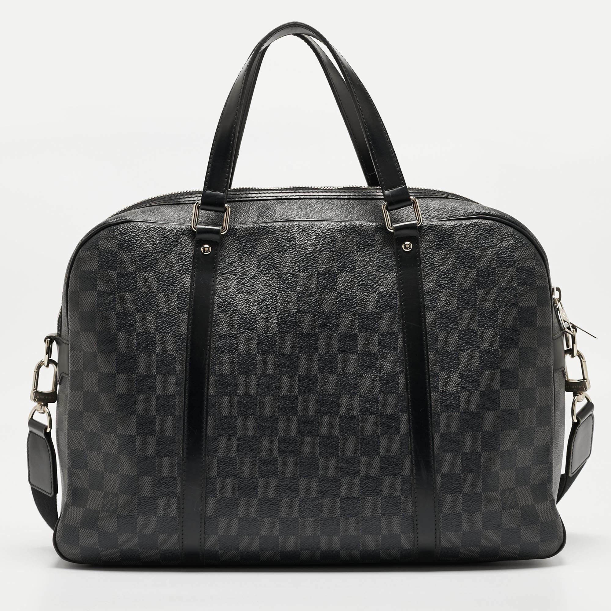 This Jorn men's bag by Louis Vuitton crafted using Damier Graphite canvas is an ideal choice for everyday work or while travelling. Crafted by combining style and practical ease, the bag is fitted with two top handles, a detachable shoulder strap,