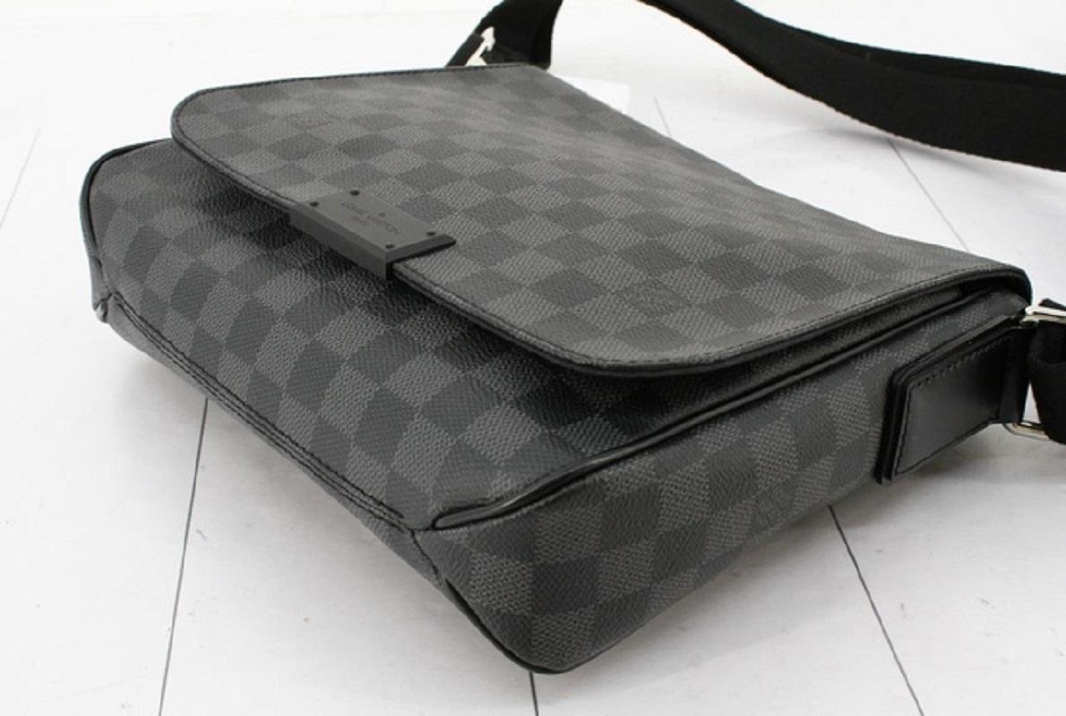 Black and gray Damier Graphite coated canvas Louis Vuitton District PM messenger bag with silver-tone hardware, black leather trim, single adjustable shoulder strap, black canvas lining & dual interior pockets and snap closure at front.


70425MSC
