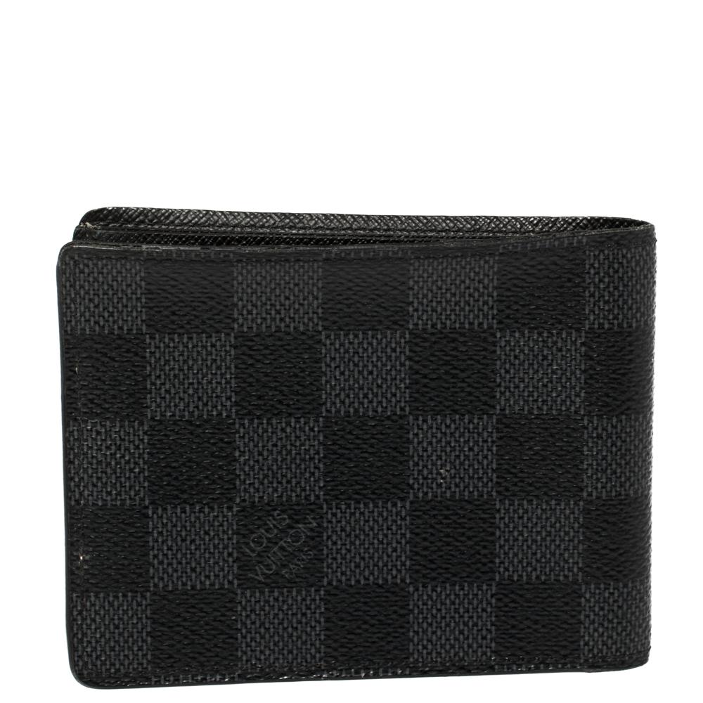Louis Vuitton's signature Damier Graphite pattern adorns the canvas body of this bifold wallet. Functional and compact, it is equipped with multiple card slots and open compartments for cash.

