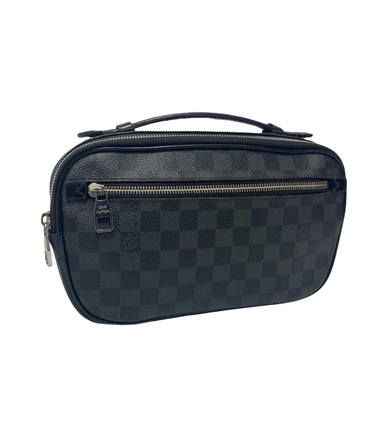   Louis Vuitton belt bag in Damier Graphite canvas and black leather with silver hardware.  It has a central opening with zip, with interior in black fabric and with 3 side pockets.  In addition, it has 2 external pockets, one on the front of the