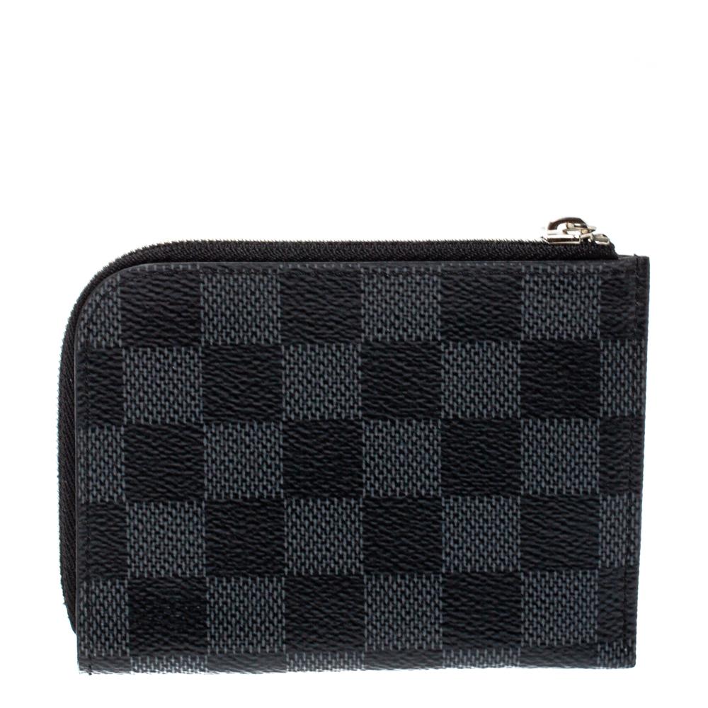 This Louis Vuitton purse is conveniently designed for everyday use. Crafted from signature Damier Graphite coated canvas, the wallet has a zip closure that opens to reveal multiple slots for you to neatly arrange your cards and
