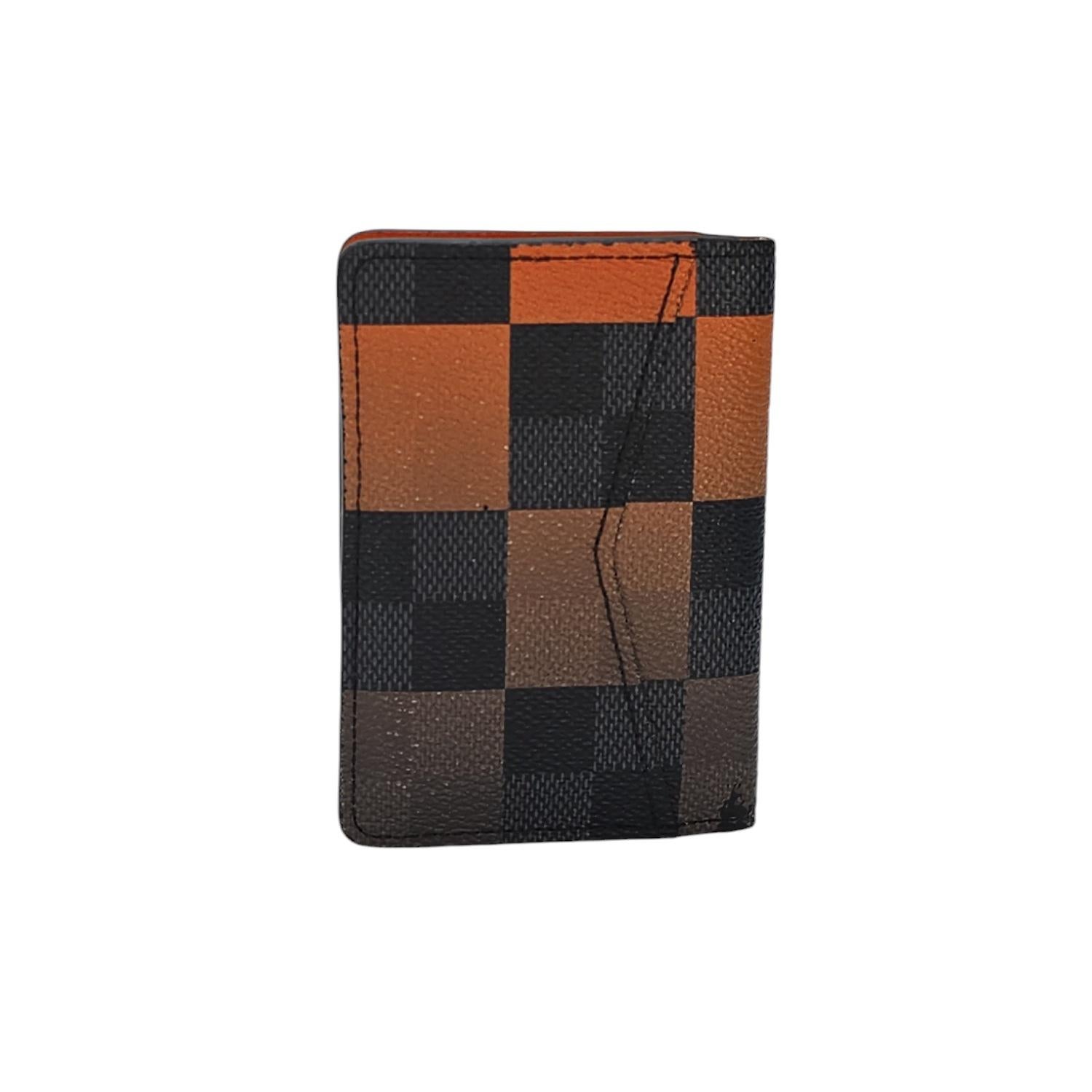 Enhance your style with this Louis Vuitton Pocket Organizer. Handcrafted in France with the iconic Damier coated canvas, this card holder boasts an elegant orange cross grain leather interior with multiple card slots and pockets. A sophisticated