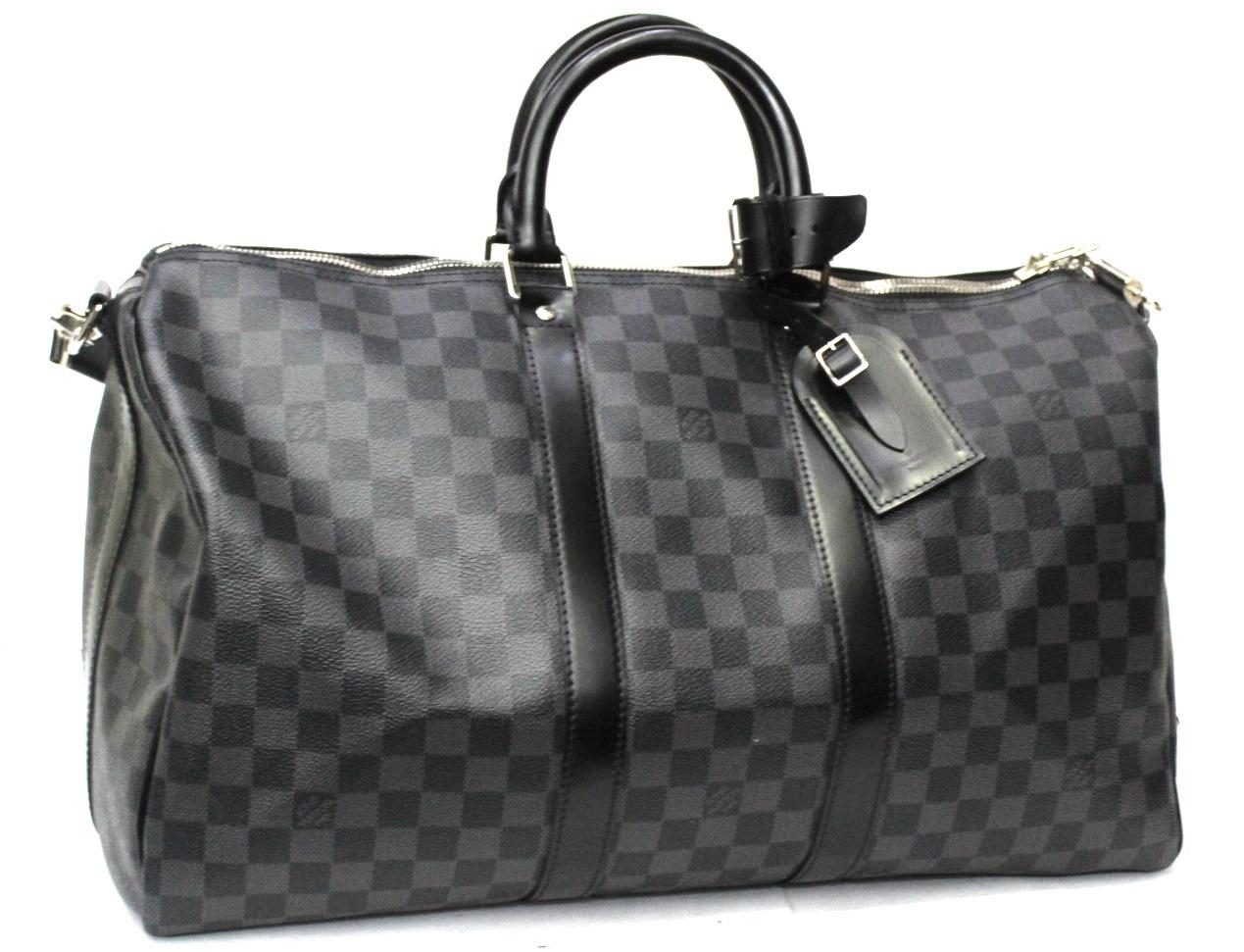 Keepall bandouliere 45 cm signed Louis Vuitton in damier graphite canvas. Cowhide details. Silver hardware. Possibility to carry it by hand and over the shoulder. Adjustable shoulder strap. Equipped with a padlock and removable leather doors.