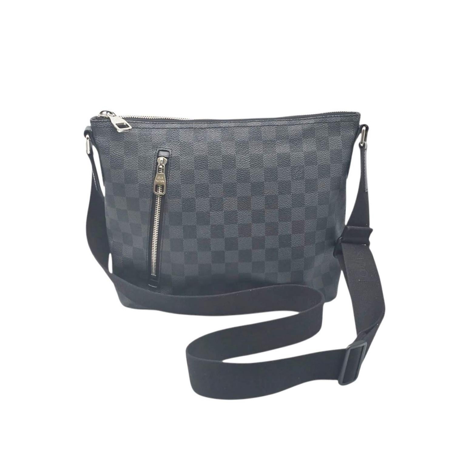 Este Louis Vuitton Damier Graphite Mick PM está finamente elaborado con lona Damier de Louis Vuitton en negro y gris. El bolso tiene una correa ajustable de lona negra con herrajes plateados y un bolsillo frontal con cremallera de fácil acceso. La