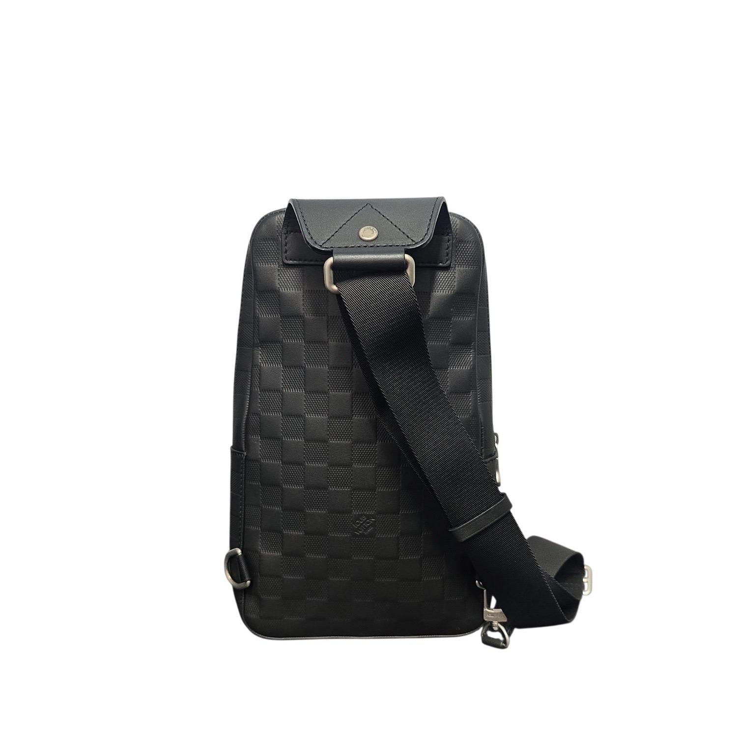 Le sac à bandouli�ère Louis Vuitton Damier Infini Avenue en Onyx présente un cuir Damier gaufré avec des ferrures argentées, incarnant le savoir-faire raffiné de l'artisanat français. Conçu pour un usage quotidien, il est doté d'une bandoulière
