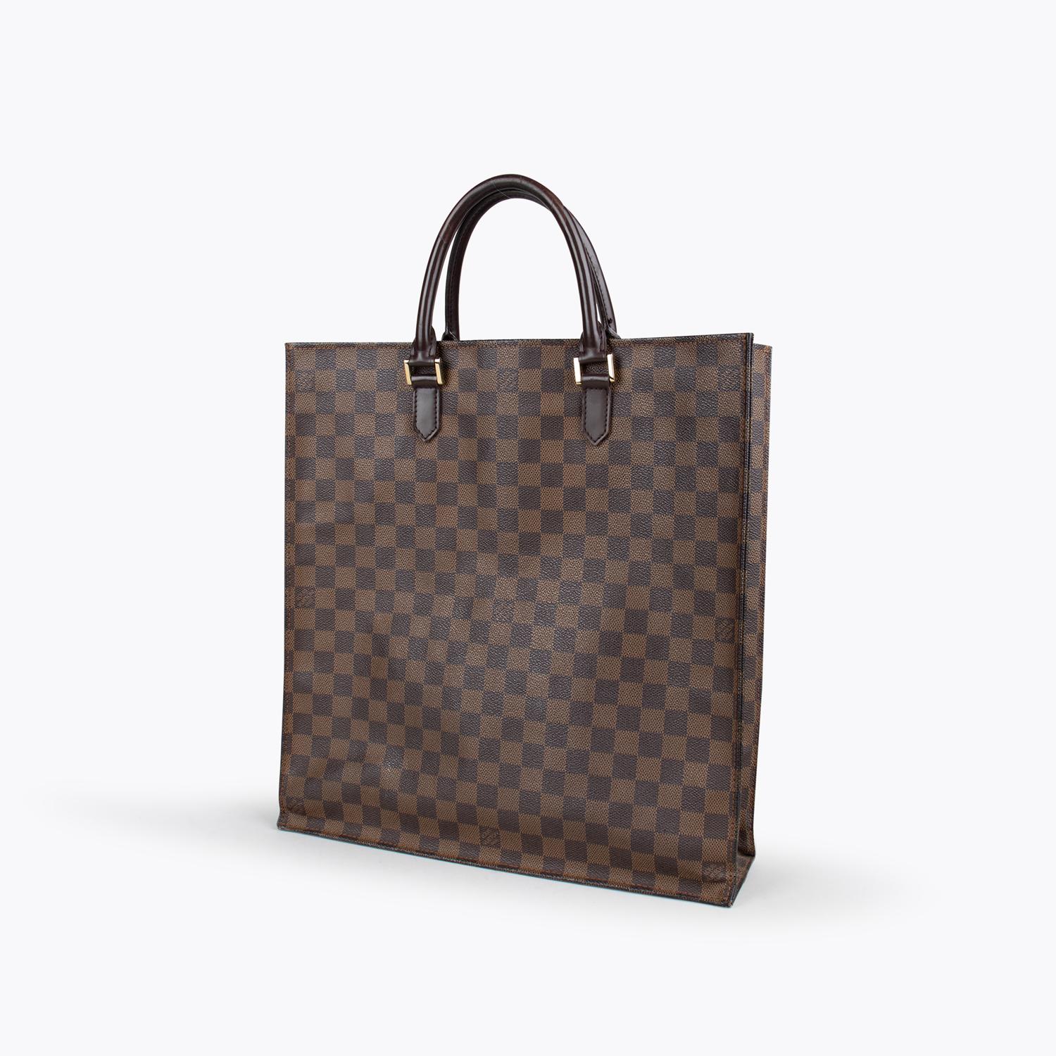 Brown monogram coated canvas Louis Vuitton Damier Sac Plat with

– Brass hardware
– Brown vachetta leather trim
– Dual rolled top handles
– Red textile lining and open top

Overall Preloved Condition: Good
Exterior Condition: Good. Moderate scuffs