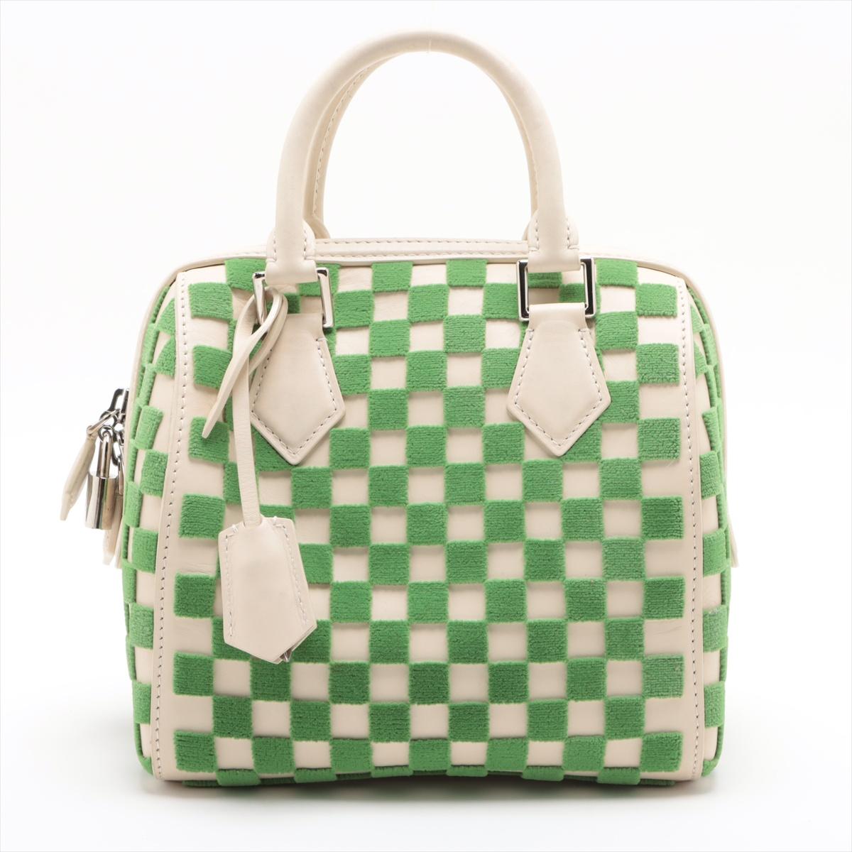 The Louis Vuitton Damier Speedy Cube PM in White and Green is a refined and modern take on the classic Speedy silhouette. The elegant bag features a combination of leather and soft green fabric with the signature Damier pattern. Designed for both