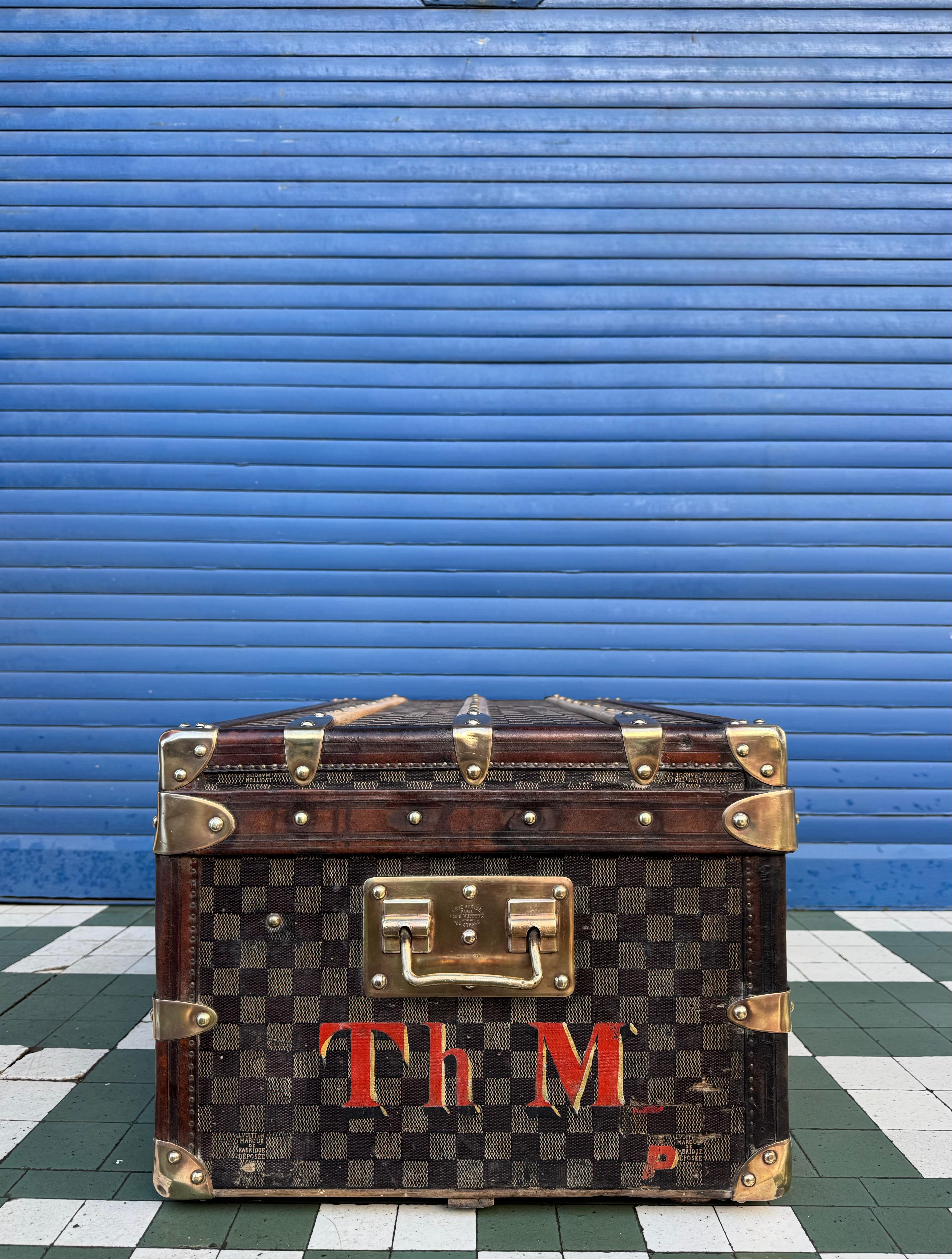 An extraordinarily rare early Louis Vuitton damier canvas trunk dating from the 1880s, featuring an exceptionally low 4-digit serial number 3644 and the highly sought after 454 Strand, London maker’s label. Louis Vuitton’s very first London address.