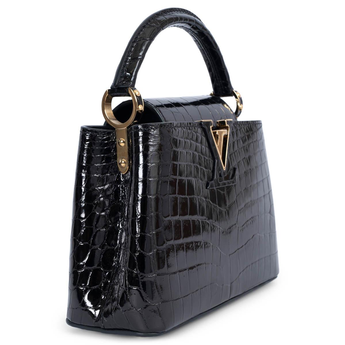 100% authentic Louis Vuitton Capucines Mini Bag in dark brown Crocodilien Brillant is polished to a high-gloss finish with sparkling gold-tone metal hardware and sumptuous goatskin lining. The iconic Capucines flap can be worn outside to showcase