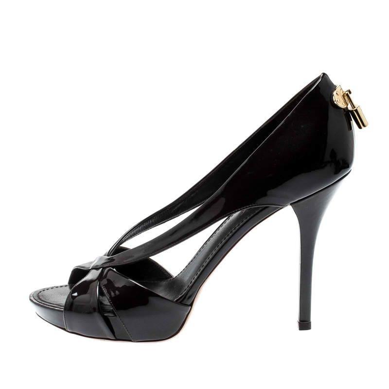 These gorgeous pumps by Louis Vuitton are stylish and chic. Crafted from dark brown patent leather, they feature open toes and platforms along with the LV padlock on the counters in gold-tone hardware. They come with crisscross design at the vamps