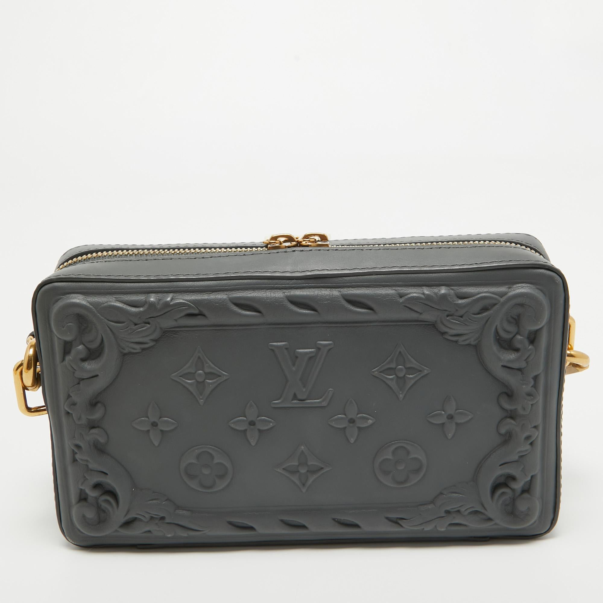Louis Vuitton's Soft Trunk Wearable Wallet is a beauty from every angle. It is crafted to look like an accent piece but is finished with practical features for you to parade any day. It has a dark grey shade with chateau-inspired debossed details