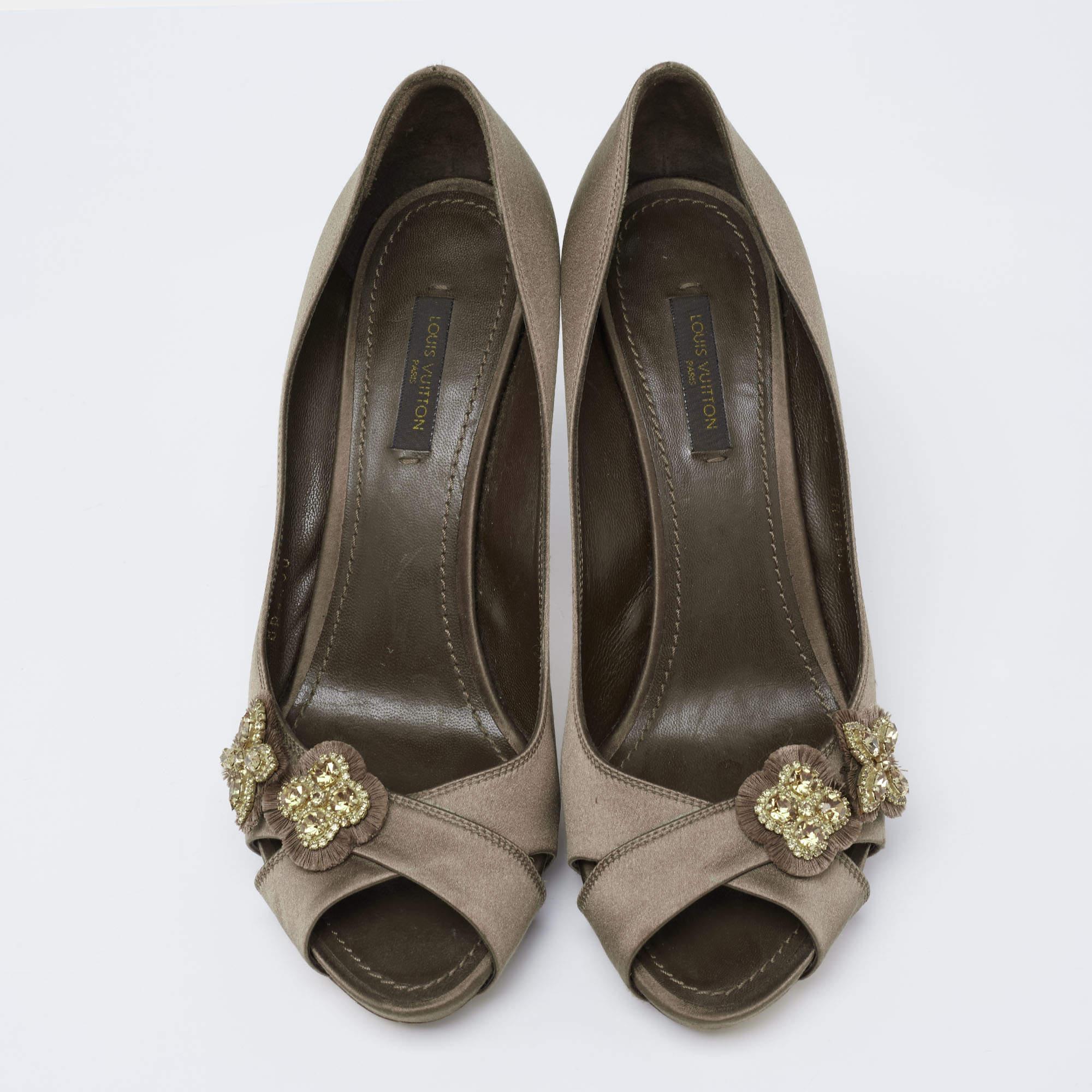 These pumps from Louis Vuitton will certainly make you appear classy and polished! They are created using dark olive-green satin on the exterior. They showcase super-slim heels, crystal embellishments on the peep toes, and a slip-on style. Look