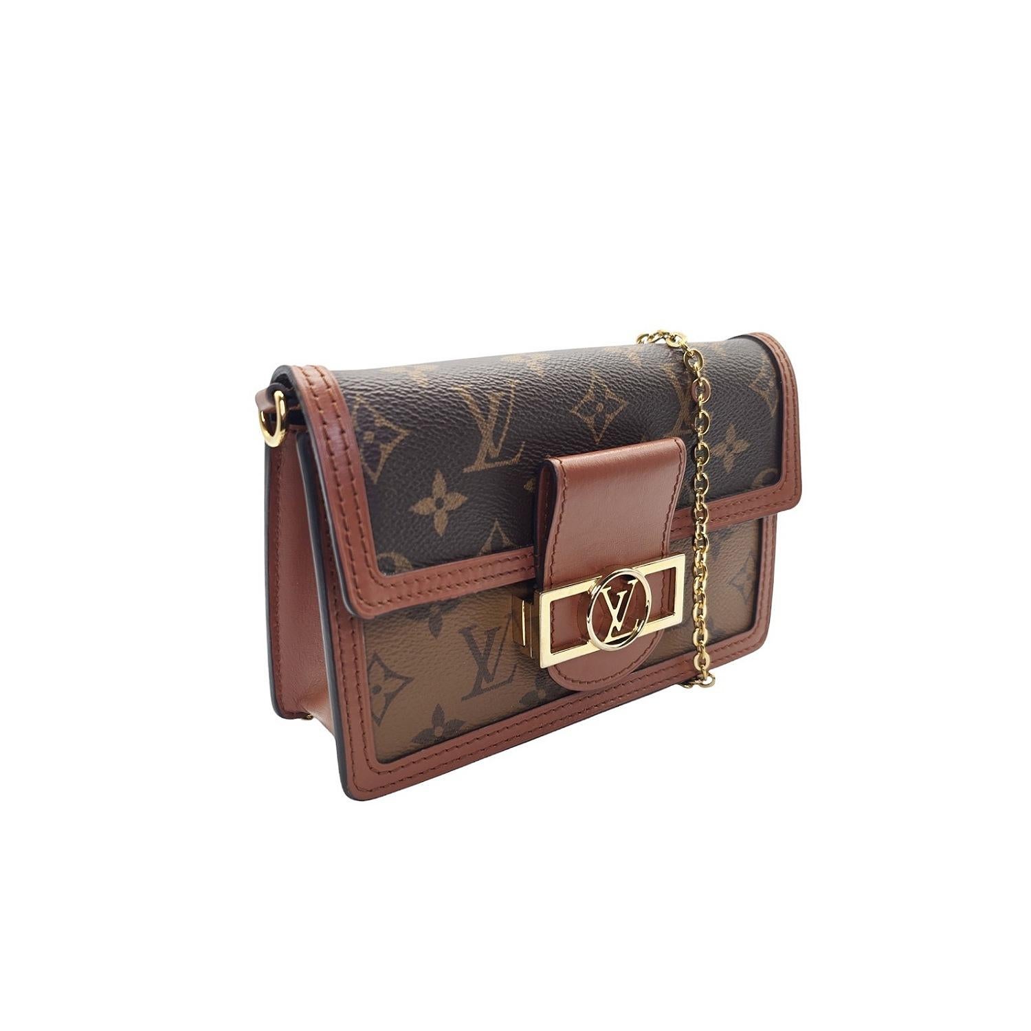 Indulge in luxury with the Louis Vuitton Dauphine Reverse Monogram Chain Wallet. Crafted from exquisite reverse monogram canvas and leather trim, this shoulder bag features a gold chain strap and a flap adorned with a gold LV logo clasp. The