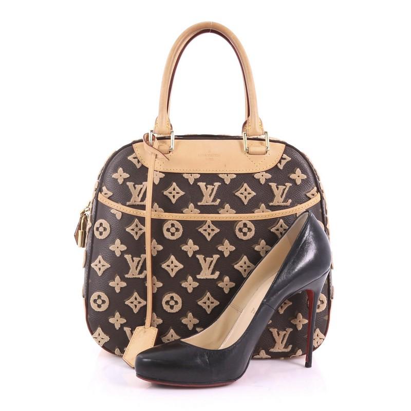 This Louis Vuitton Deauville Cube Bag Limited Edition Monogram Canvas Tuffetage, crafted in brown monogram canvas tuffetage, features dual rolled leather handles, exterior front pocket, protective base studs and gold-tone hardware. Its two-way zip