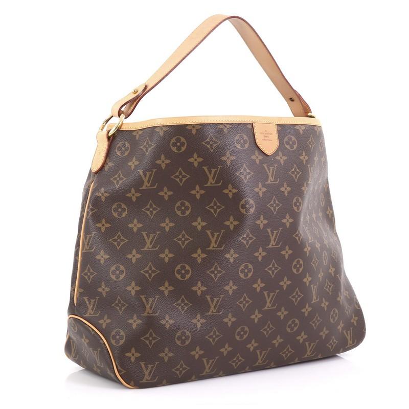 This Louis Vuitton Delightful Handbag Monogram Canvas MM, crafted in brown monogram coated canvas, features a flat leather loop handle, cowhide leather trim, and gold-tone hardware. Its snap hook closure opens to a light brown fabric interior with